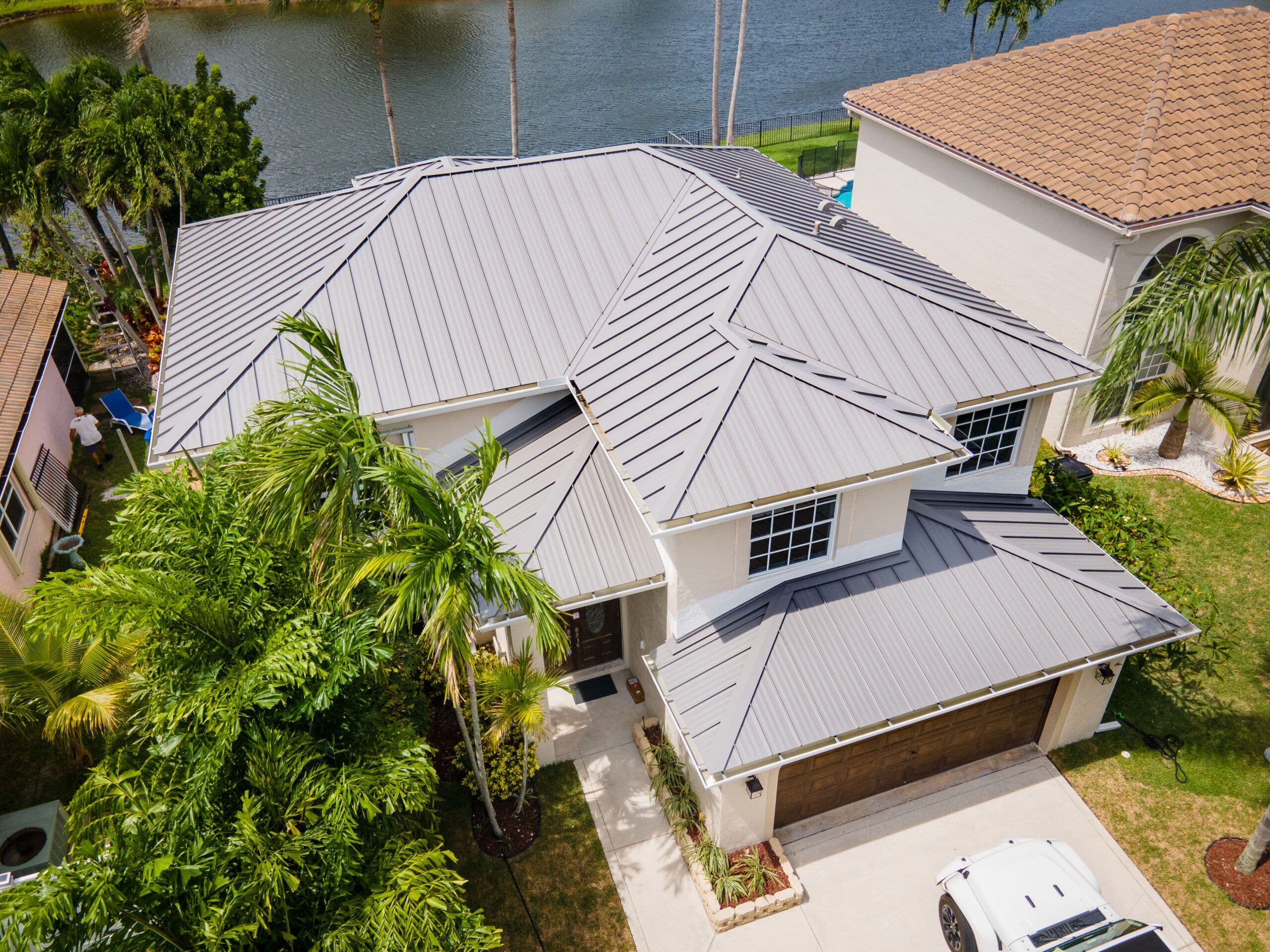Aerial view of a Florida home with standing-seam metal roof on a canal